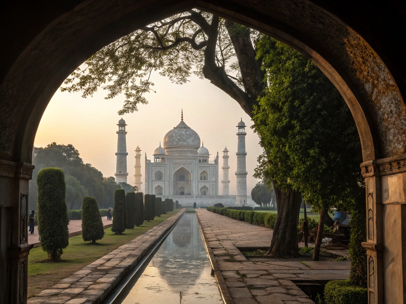 Bibi ka Maqbara framed by garden trees and arched gateway with evening light